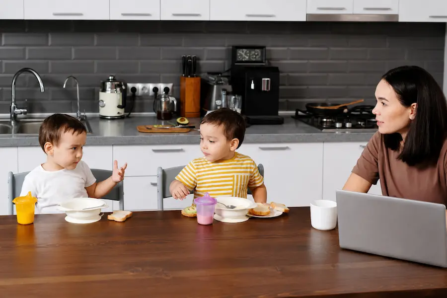 Babá conversando com mãe na cozinha reportando o dia da criança