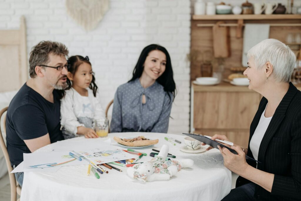 Babá em entrevista de emprego com família sorrindo em sala de estar