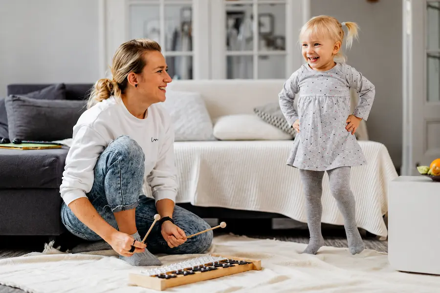 Babá profissional brincando com criança pequena em ambiente doméstico