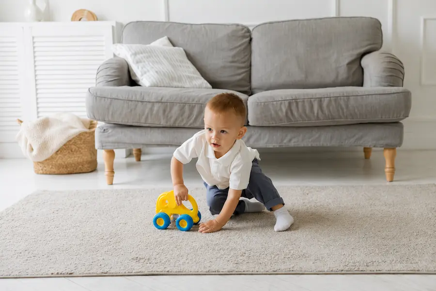 Criança pequena brincando feliz e segura sob os cuidados atentos da babá