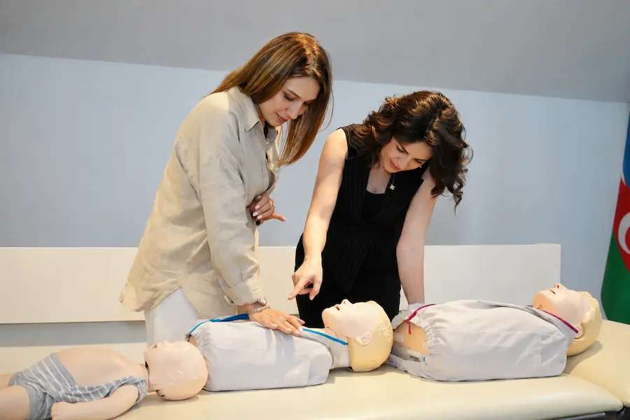 Curso de primeiros socorros pediátrico com manequim de bebê em sala de treinamento