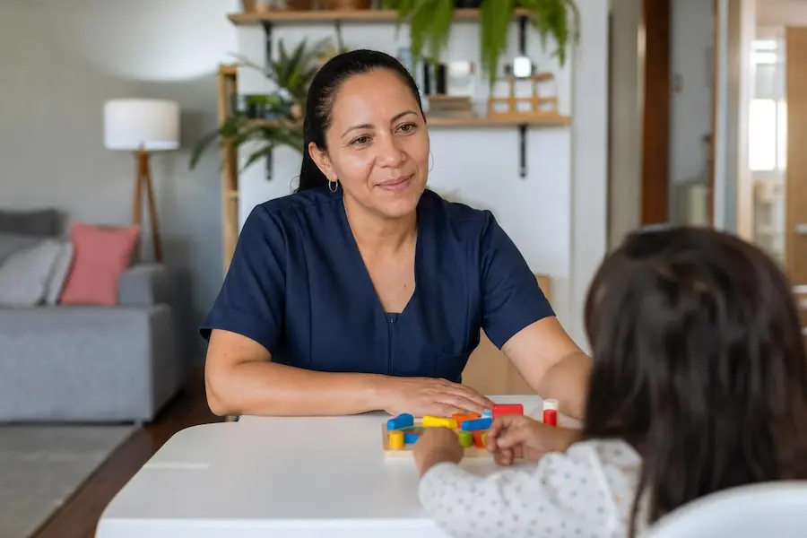 Babá brincando com criança durante o cuidado diário, ilustrando quanto pagar de babá por hora em 2026